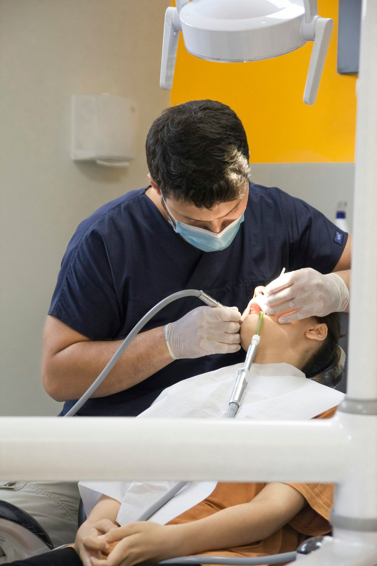 Behandlung eines Patienten, die Behandelnden tragen Mundschutz